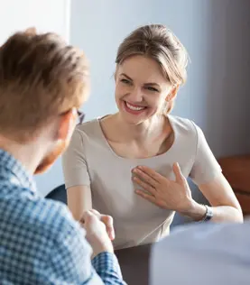 Ein Mann dankt einer Frau per Handschlag und sie freut sich darüber