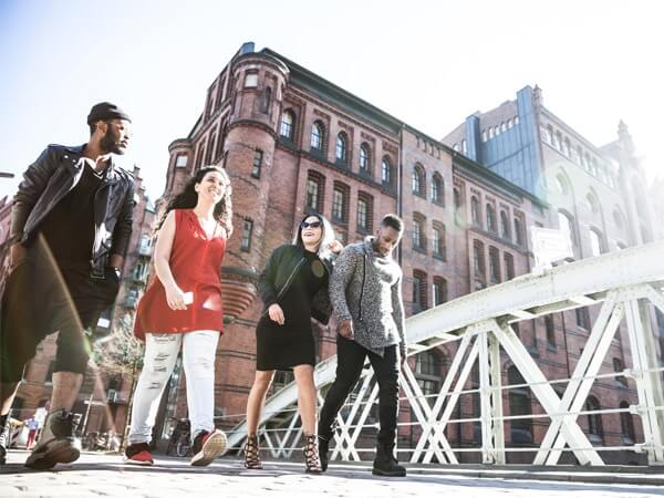 4 junge Menschen gehen über eine Brücke in der Speicherstadt