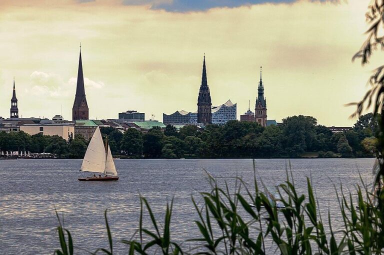Segelboot auf der Alster vor der Kulisse von Hamburg