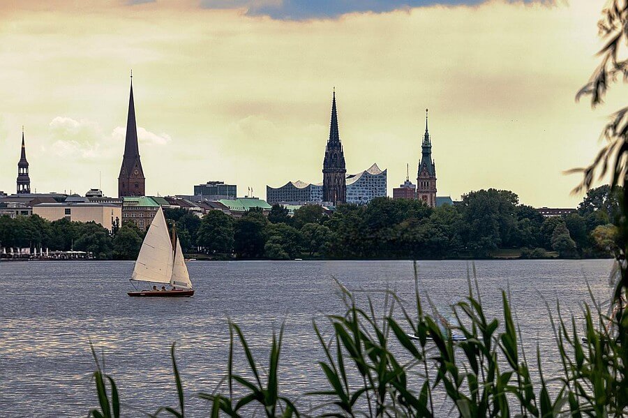 Segelboot auf der Alster vor der Kulisse von Hamburg