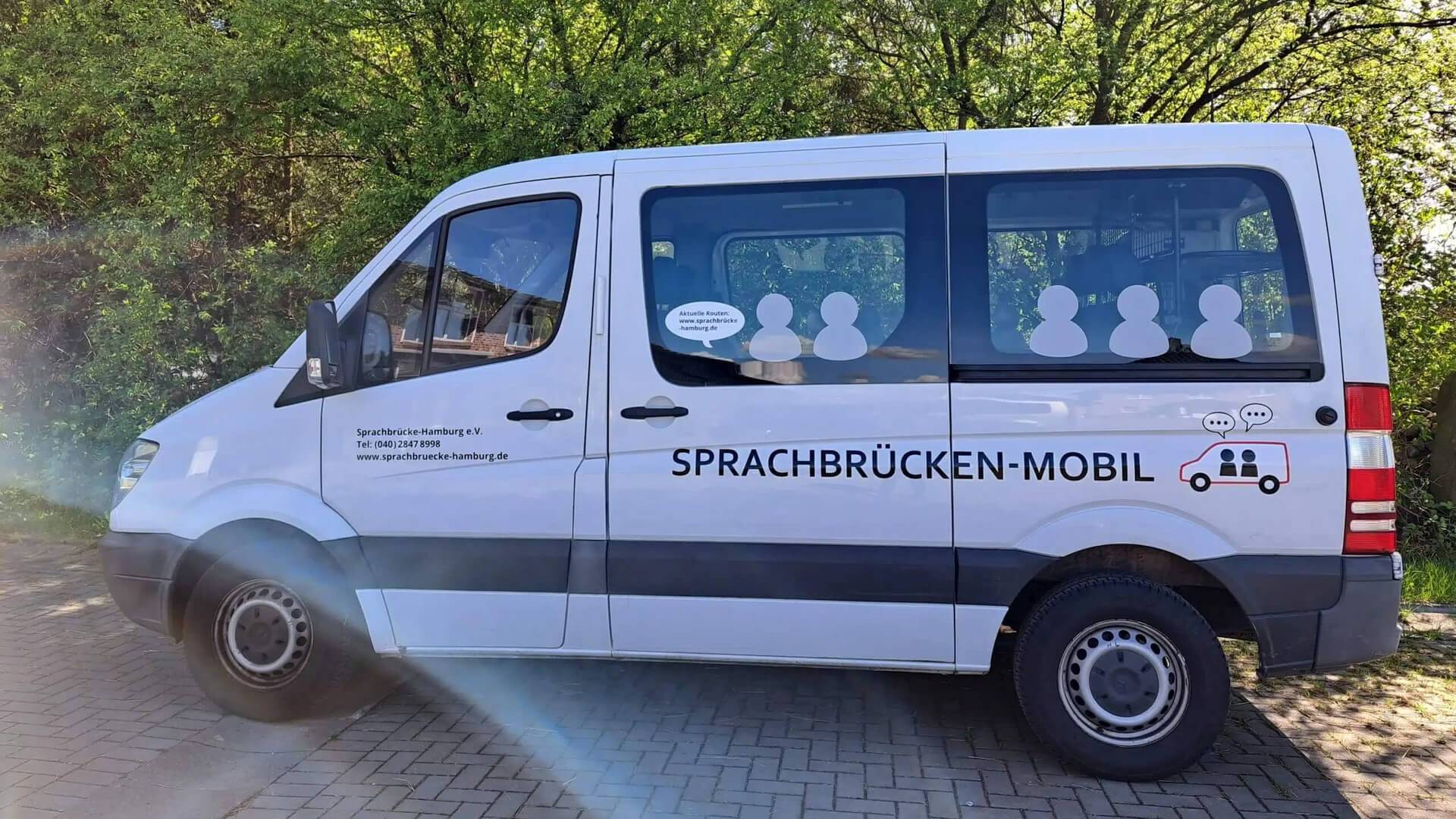 Ein weißer Sprinter mit dem Schriftzug Sprachbrücken-Mobil
